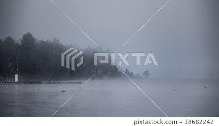 Forest and water in heavy fog rising from Ottawa R 18682242