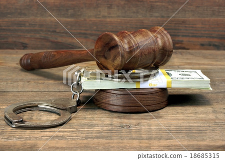 Cash , Handcuffs and Judges Gavel on wood table 18685315