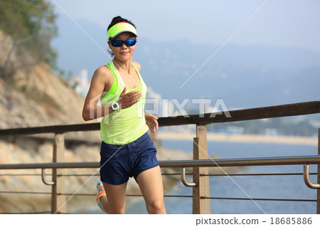 sports woman running on wooden boardwalk seaside 18685886