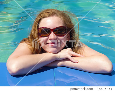 Happy blond woman by the pool Happy blond woman by the pool 18693234