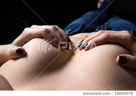 Woman's hands hold breasts in the dark 18693679