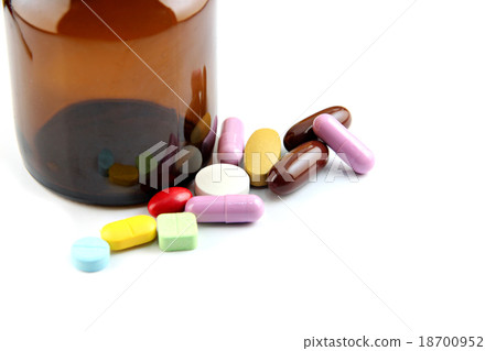 Pill of many color Beside the bottle. 18700952