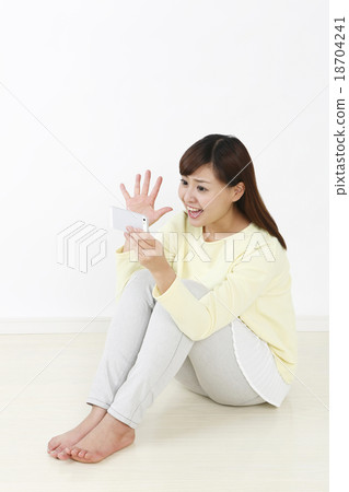 A woman enjoying with a smartphone A woman enjoying with a smartphone 18704241