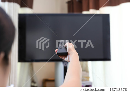 Hand holding remote control changing television  18718878