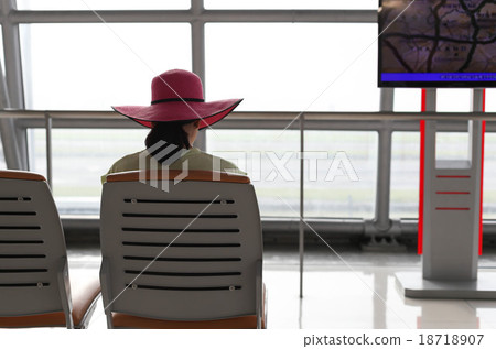 Woman waiting for a flight in the airport terminal Woman waiting for a flight in the airport terminal 18718907
