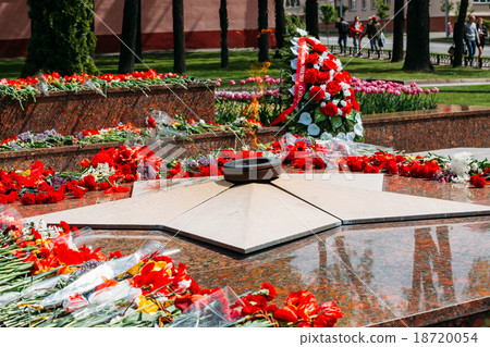 Wreaths and flowers lie on a communal grave of 18720054