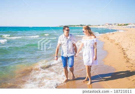enamored couple posing on a beach 18721011