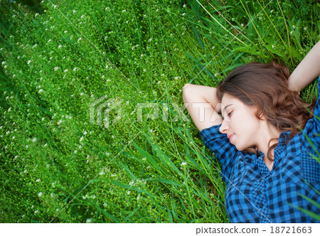 happy woman lying on the grass and dreaming happy woman lying on the grass and dreaming 18721663