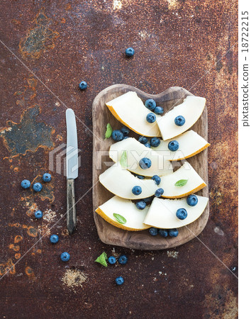 Melon and blueberries in a rustic wooden serving Melon and blueberries in a rustic wooden serving 18722215