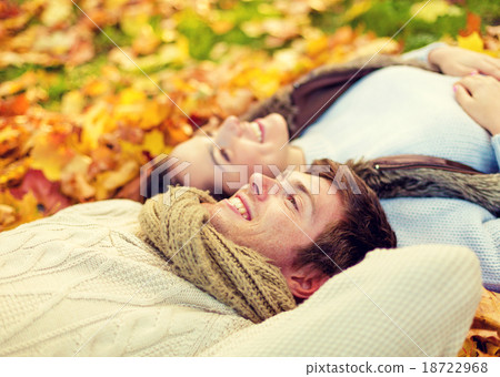 close up of smiling couple lying in autumn park 18722968