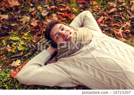 close up of smiling young man lying in autumn park close up of smiling young man lying in autumn park 18723207