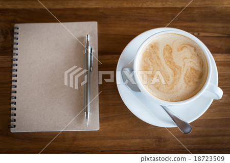 Hot latte art coffee cup on table and note book Hot latte art coffee cup on table and note book 18723509