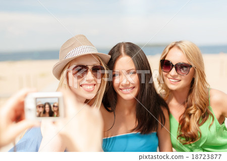 girls taking photo with digital camera in cafe girls taking photo with digital camera in cafe 18723877