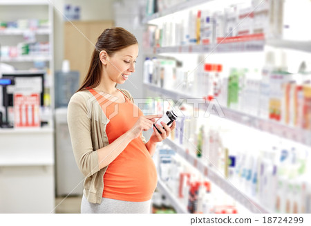 happy pregnant woman with medication at pharmacy happy pregnant woman with medication at pharmacy 18724299