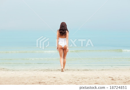 young woman in swimsuit walking on beach young woman in swimsuit walking on beach 18724851