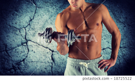 close up of young man with dumbbell flexing biceps 18725522