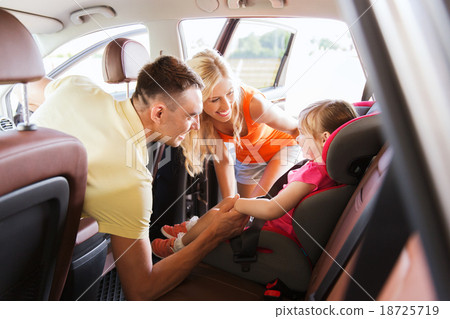 Stock Photo: parents talking to little girl in baby car seat