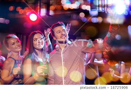 friends taking selfie by smartphone in night club 18725906