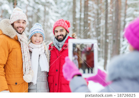 smiling friends with tablet pc in winter forest smiling friends with tablet pc in winter forest 18726025