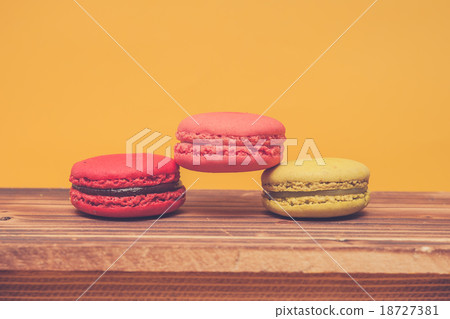 Pile of colorful macarons stacked up in yellow Pile of colorful macarons stacked up in yellow 18727381