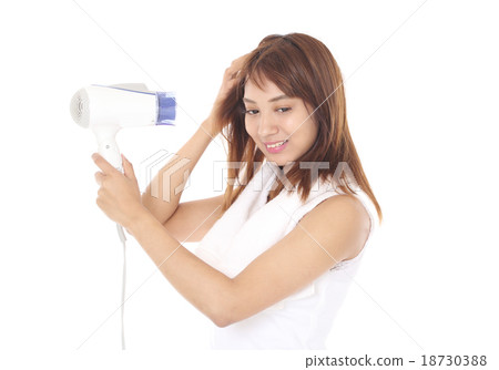 A woman wearing a shampoo and drying his hair with a hair dryer A woman wearing a shampoo and drying his hair with a hair dryer 18730388