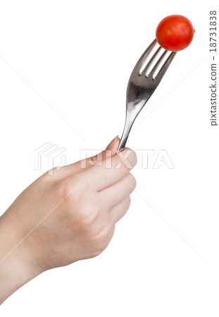 hand holding fork with one fresh red cherry tomato 18731838