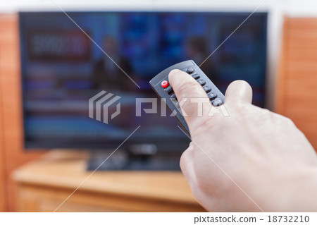 Hand turns on News on TV by remote control Hand turns on News on TV by remote control 18732210
