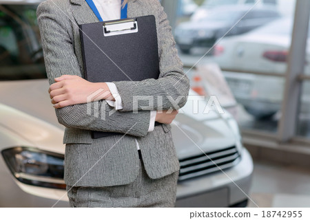 Saleswoman with clipboard is standing beside the Saleswoman with clipboard is standing beside the 18742955