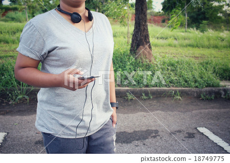 Woman listening to music on earphone with smart phone 18749775