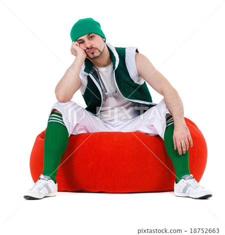 Melancholy man dressed like a gnome sitting on red 18752663