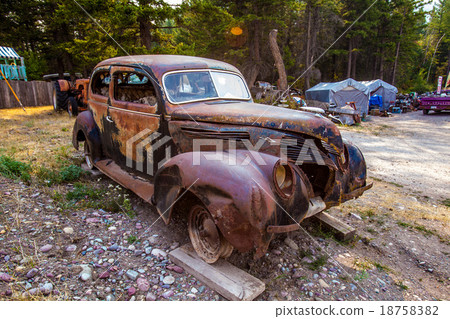 Old rusted car in junk yard 18758382