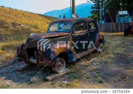 Old rusted car in junk yard 18758384
