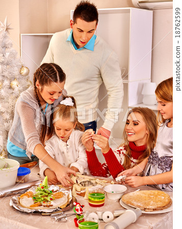 Family with children rolling dough in Xmas kitchen Family with children rolling dough in Xmas kitchen 18762599