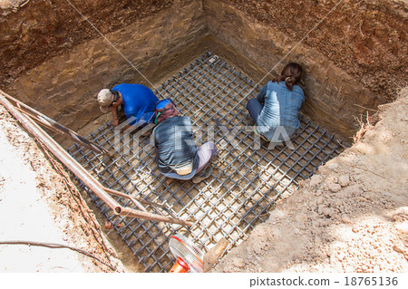 Workers are digging a hole and tie steel Workers are digging a hole and tie steel 18765136