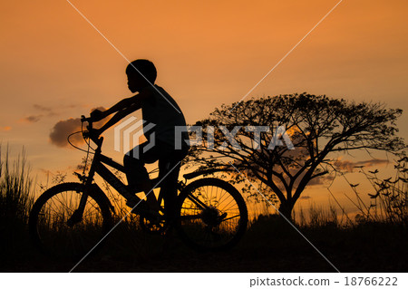Silhouette of a children and bicycle on sunset Silhouette of a children and bicycle on sunset 18766222