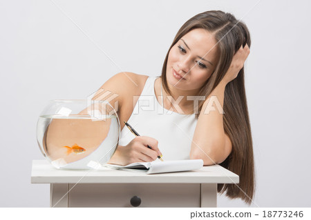 Girl writing notebook desire to fulfill a goldfish 18773246