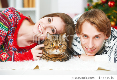 Happy family couple and a cat in Christmas at home 18774010