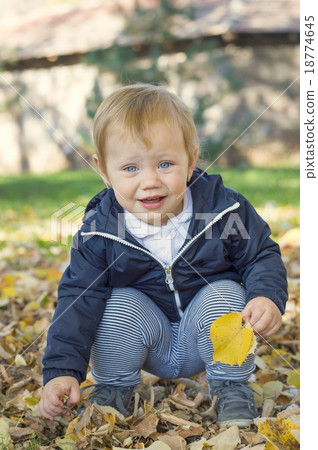 Cute one year old baby girl sitting on grass in a park 18774645