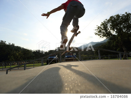 skateboarder legs doing a trick ollie at skatepark 18784086