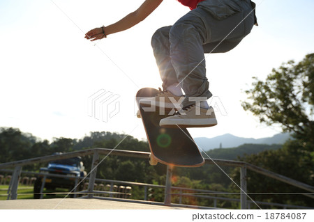 skateboarder legs doing a ollie at skatepark 18784087