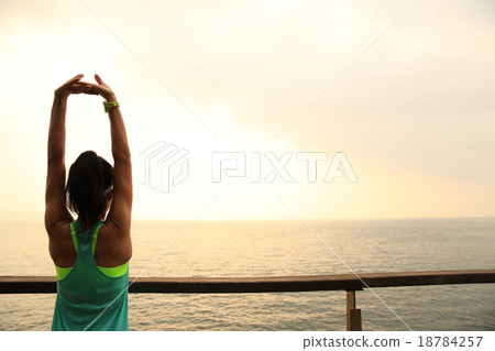 woman runner stretching on wooden boardwalk  18784257