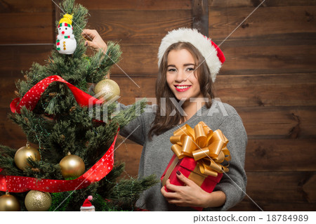 Beautiful girl decorating New Year tree at home 18784989