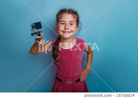 Girl child holding a camera in his hand shooter Girl child holding a camera in his hand shooter 18788024