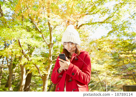 A woman using a smartphone outside A woman using a smartphone outside 18789114