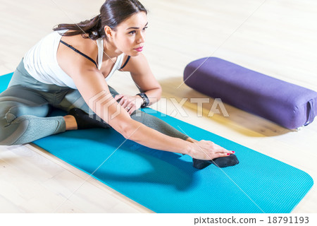 Fit woman doing stretching pilates exercises in 18791193