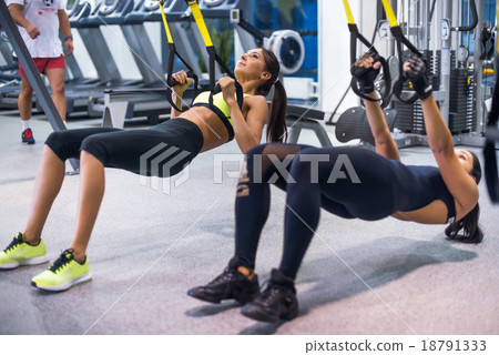 Woman exercising with suspension straps in fitness 18791333