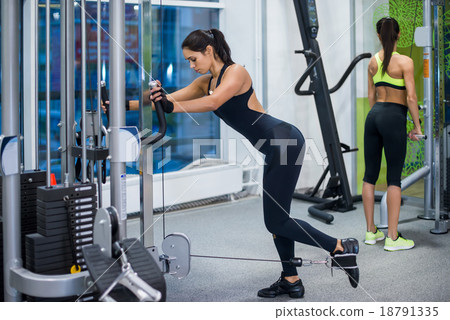 Woman exercising with crossover in fitness club or Woman exercising with crossover in fitness club or 18791335