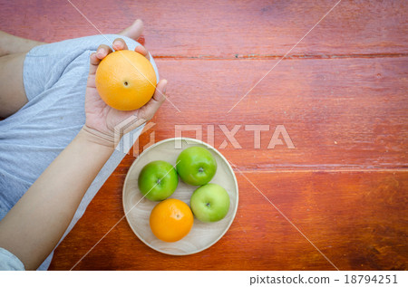Close up pregnant belly holding oranges in hand Close up pregnant belly holding oranges in hand 18794251