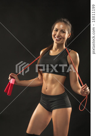 Muscular young woman athlete with a skipping rope 18811199