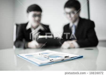 Two managers discussing contract in meeting room 18816072